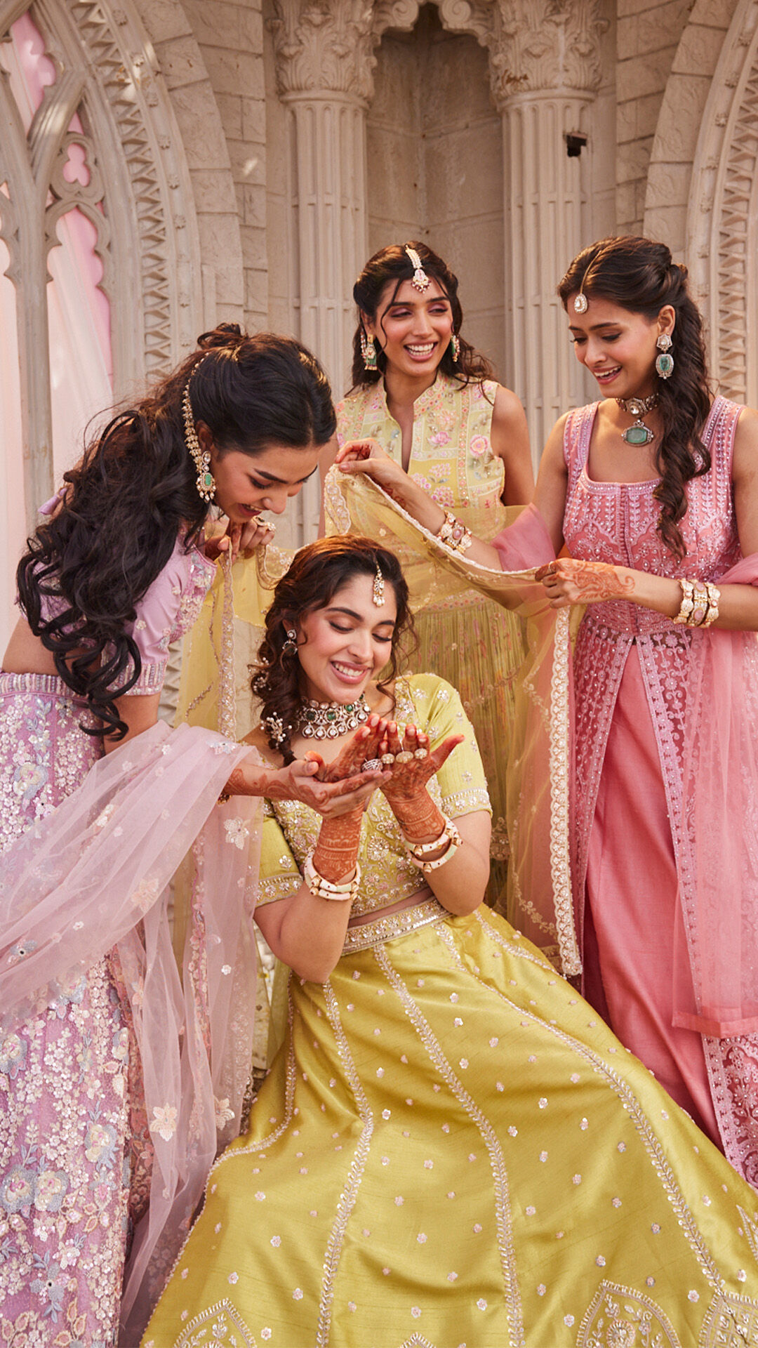 Bride with her freinds flaunting her mehendi wearing yellow lehenga 